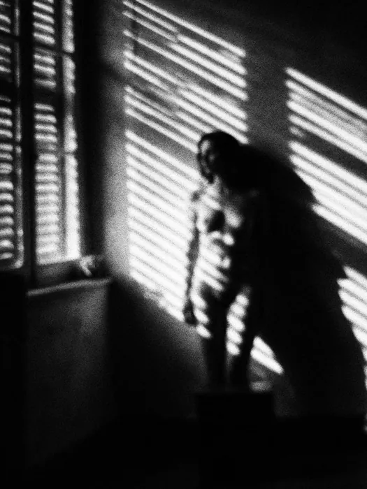 Figure dans la lumière des persiennes